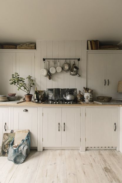 Cream kitchen ideas with standard tongue and groove cream shaker kitchen and pots hung above the stove