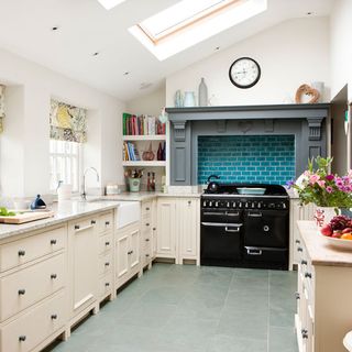 attic kitchen area with white kitchen units and black cooker with oven