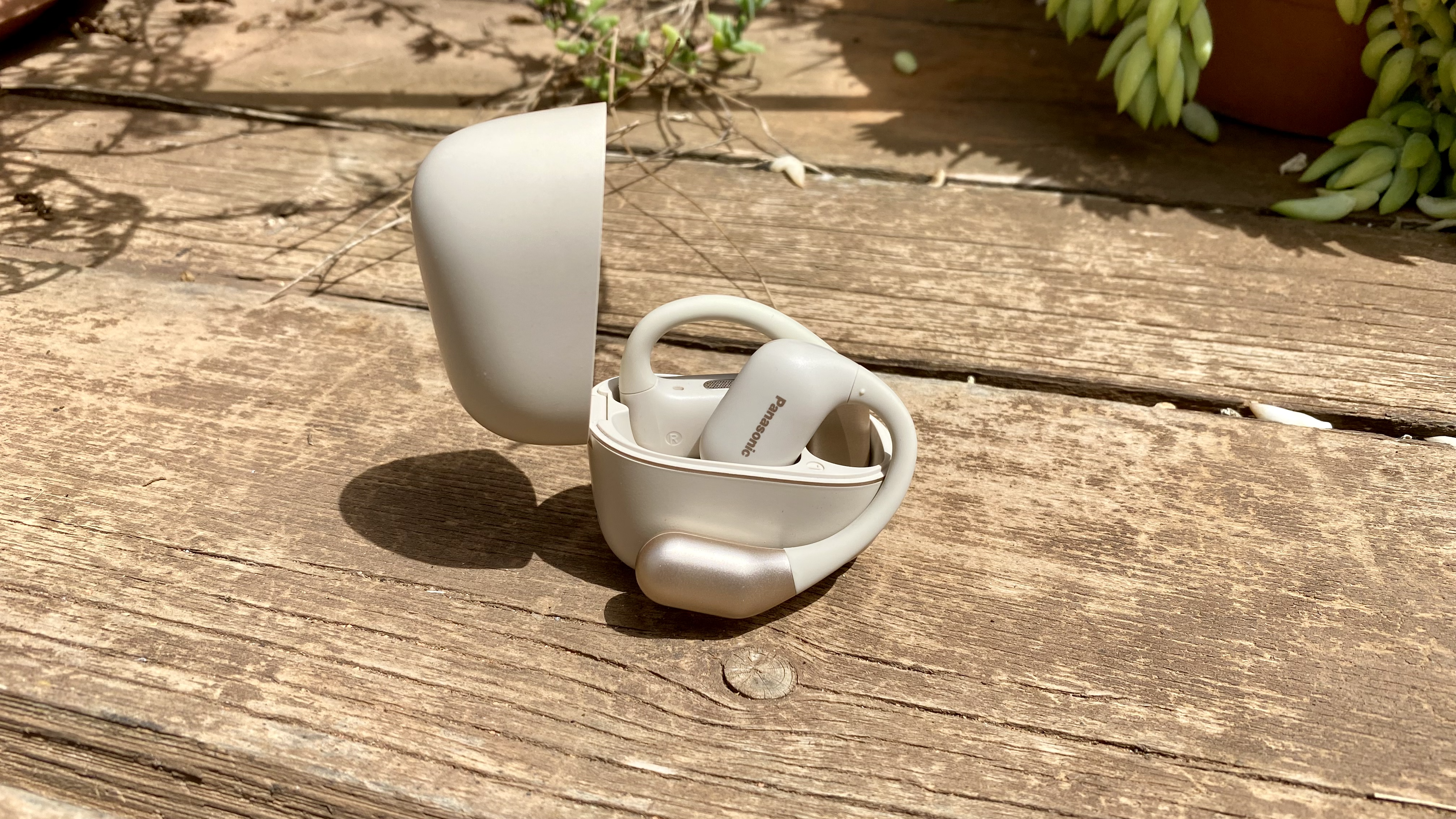 Panasonic RB-F10 open earbuds and carrying case on a wooden surface