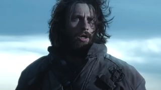 Aaron Taylor-Johnson stands in a windy scene looking horrified in 28 Years Later.