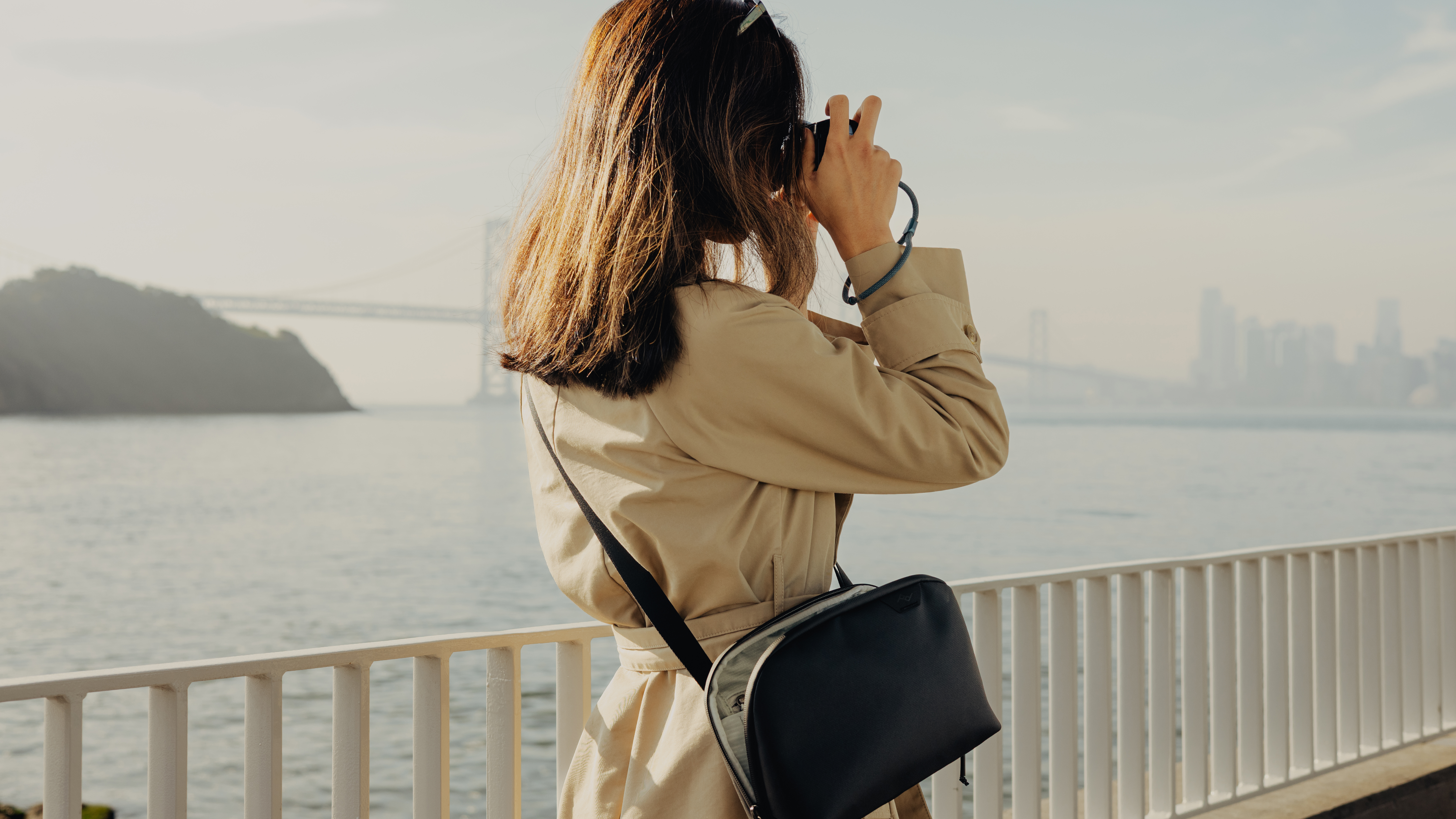 A photographer wearing the Peak Design Travel Crossbody sling