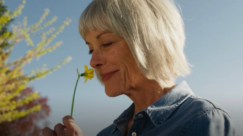 Gus smelling a flower in a scene from The Chicken Sisters