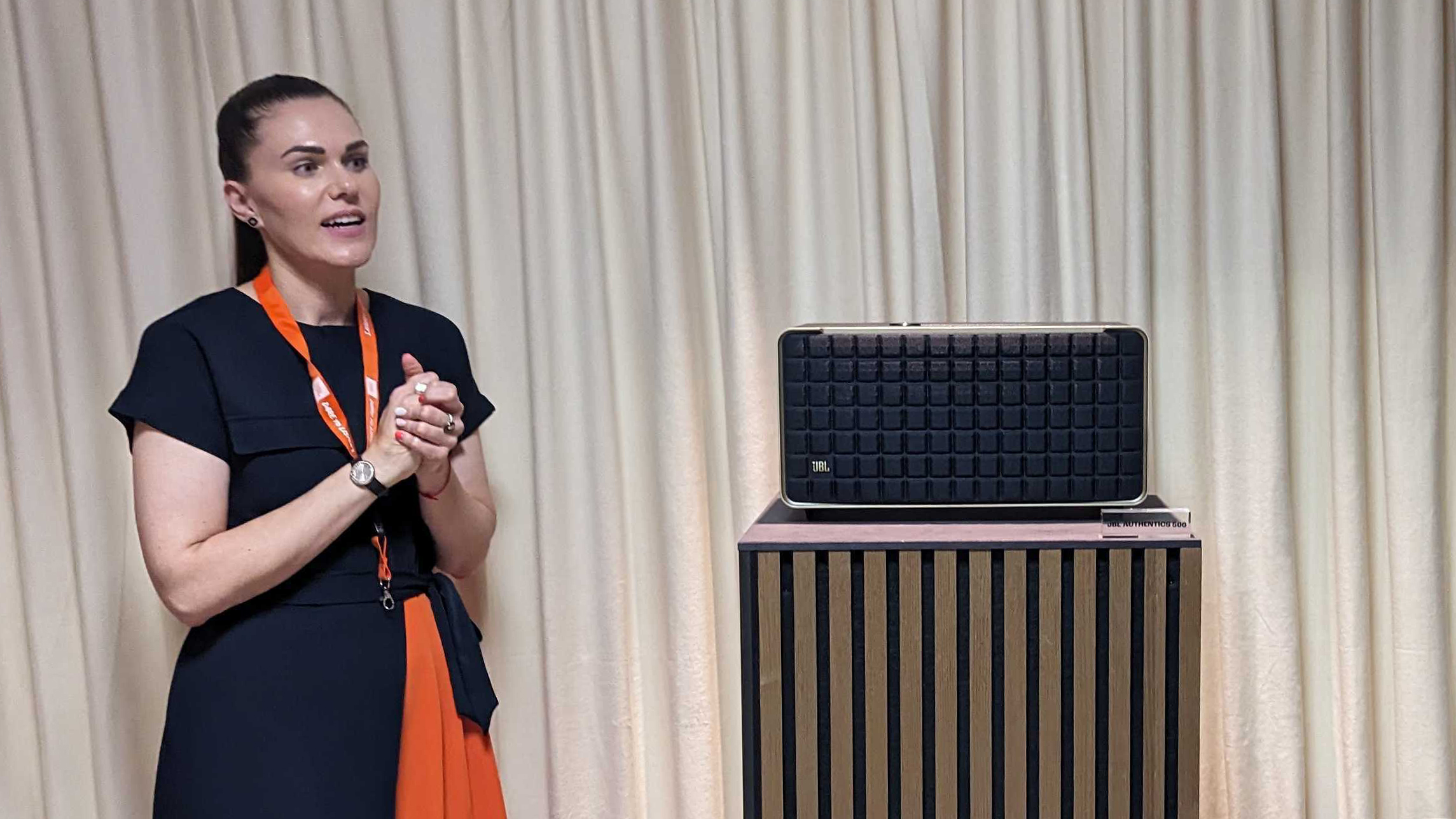 A JBL Authentics speaker on a table next to a presenter at the IFA trade show