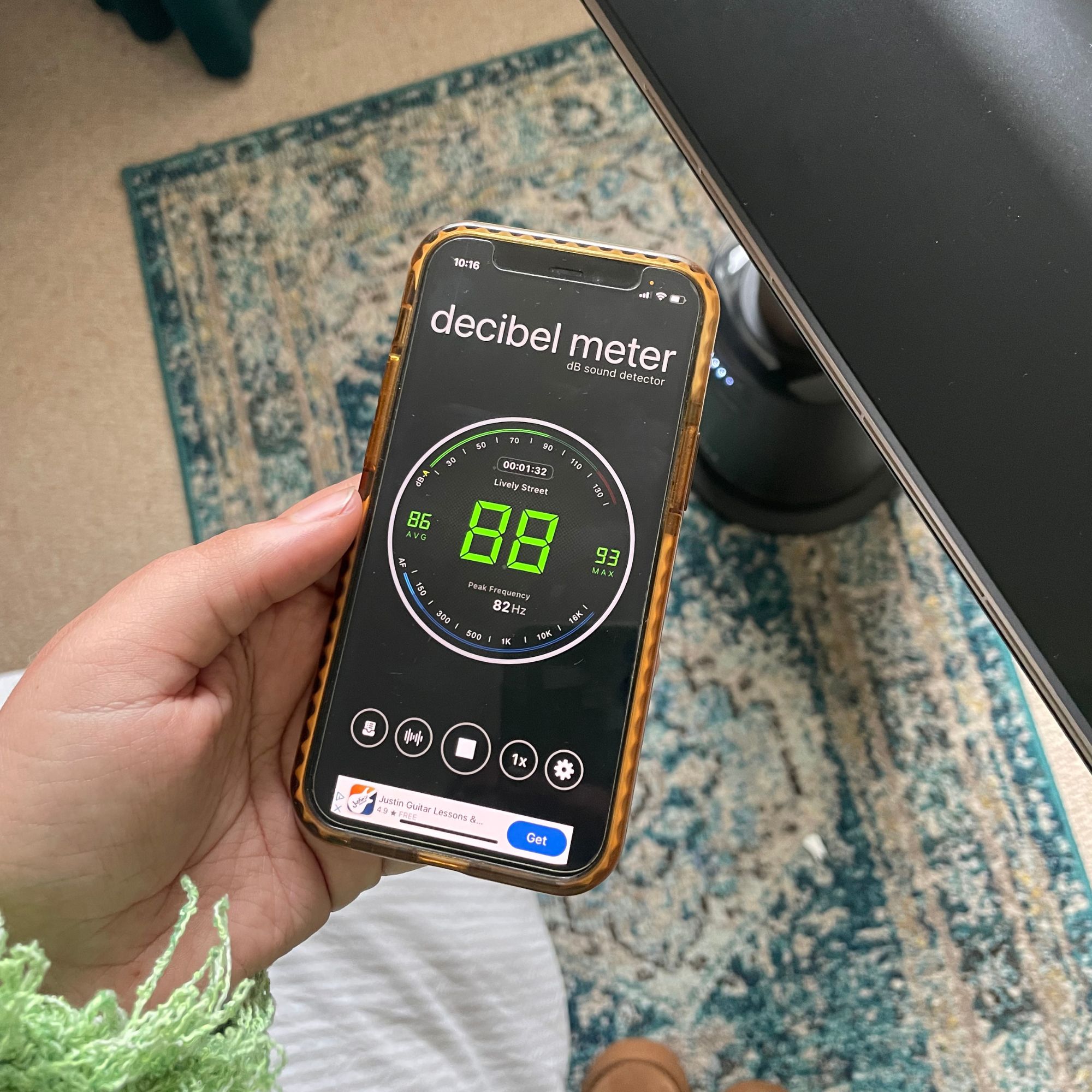 Holding a phone with a decibel meter on it next to the Shark TurboBlade