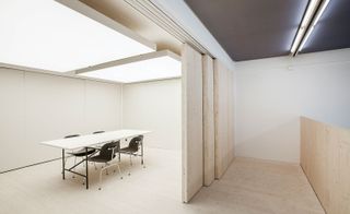 Small room with table and chairs and large lighting on ceiling