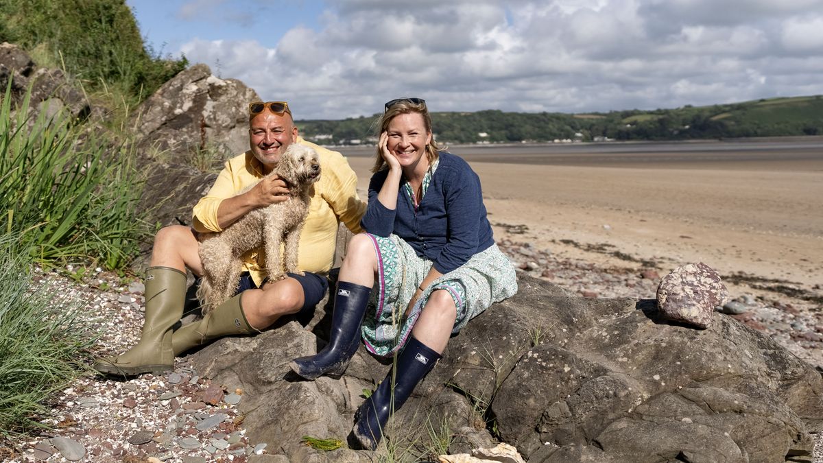 Wynne and Joanna looking relaxed as they sit on a rock on the beach with Wynne&#039;s dog