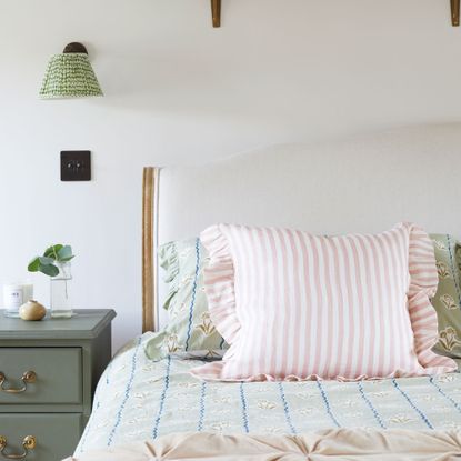 Pink striped ruffle cushions on bed