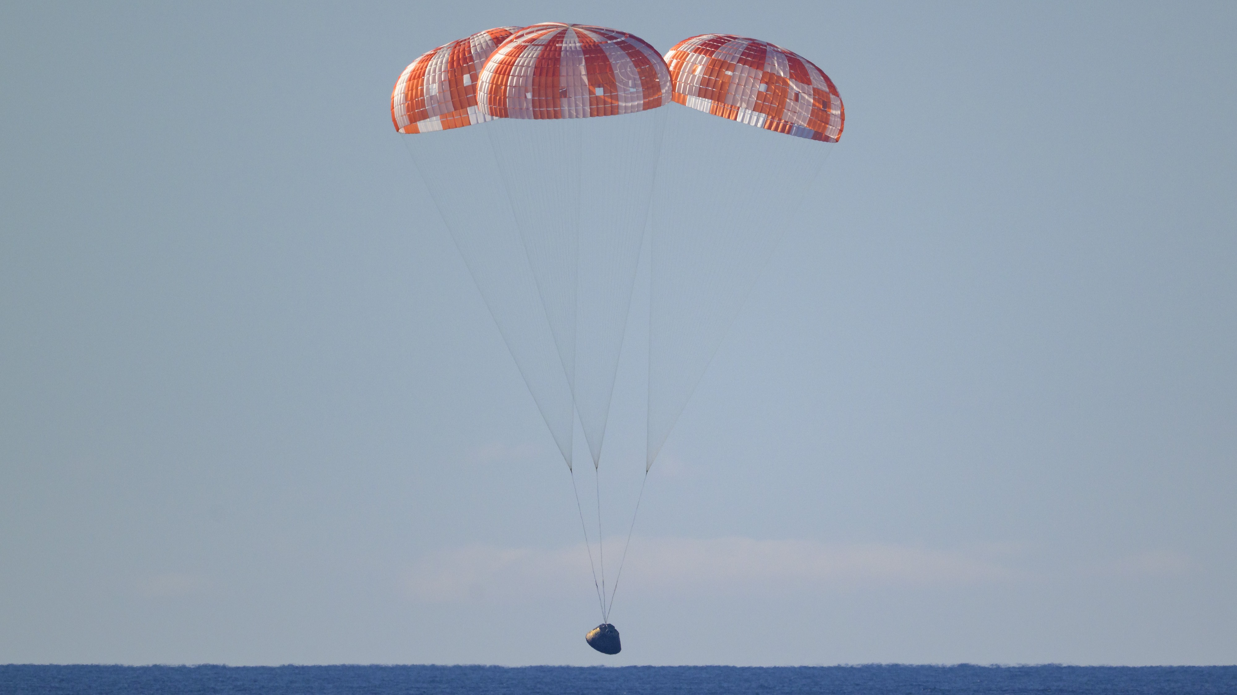 Artemis II's Orion capsule floating down into the Pacific Ocean