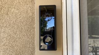 En svart Eufy Video Doorbell 2K sitter monterad bredvid en dörr.