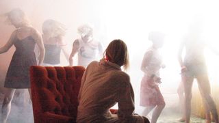 Laura Dern as Nikki Grace looking at woman dancing in the mist during one of David Lynch's best movies, Inland Empire.