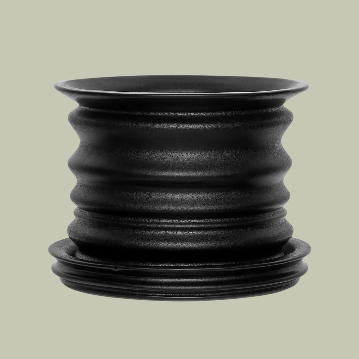 A ridged black planter with a saucer