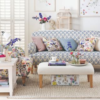 A bright living room with a floral-print sofa and armchair