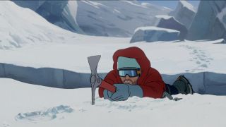 A man holds onto a pick axe, trying not to fall into a crevasse in The Summit of the Gods.
