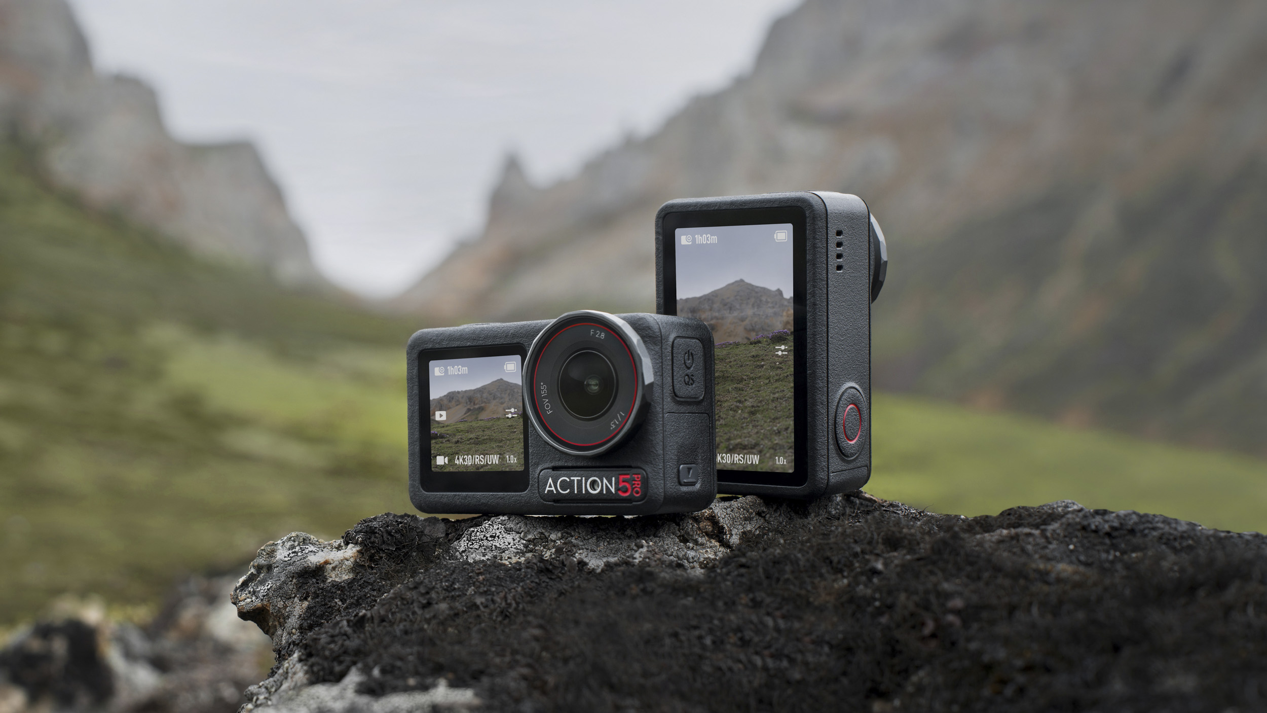 Two DJI Osmo Action 5 Pro cameras on a rock, front and back, with mountain backdrop