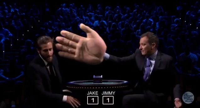 Jimmy Fallon slaps Jake Gyllenhaal with a giant rubber hand.