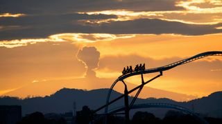 A fairground ride in Bogotá, Colombia, is pictured against the Nevado del Ruiz volcano as it emits a cloud of ash