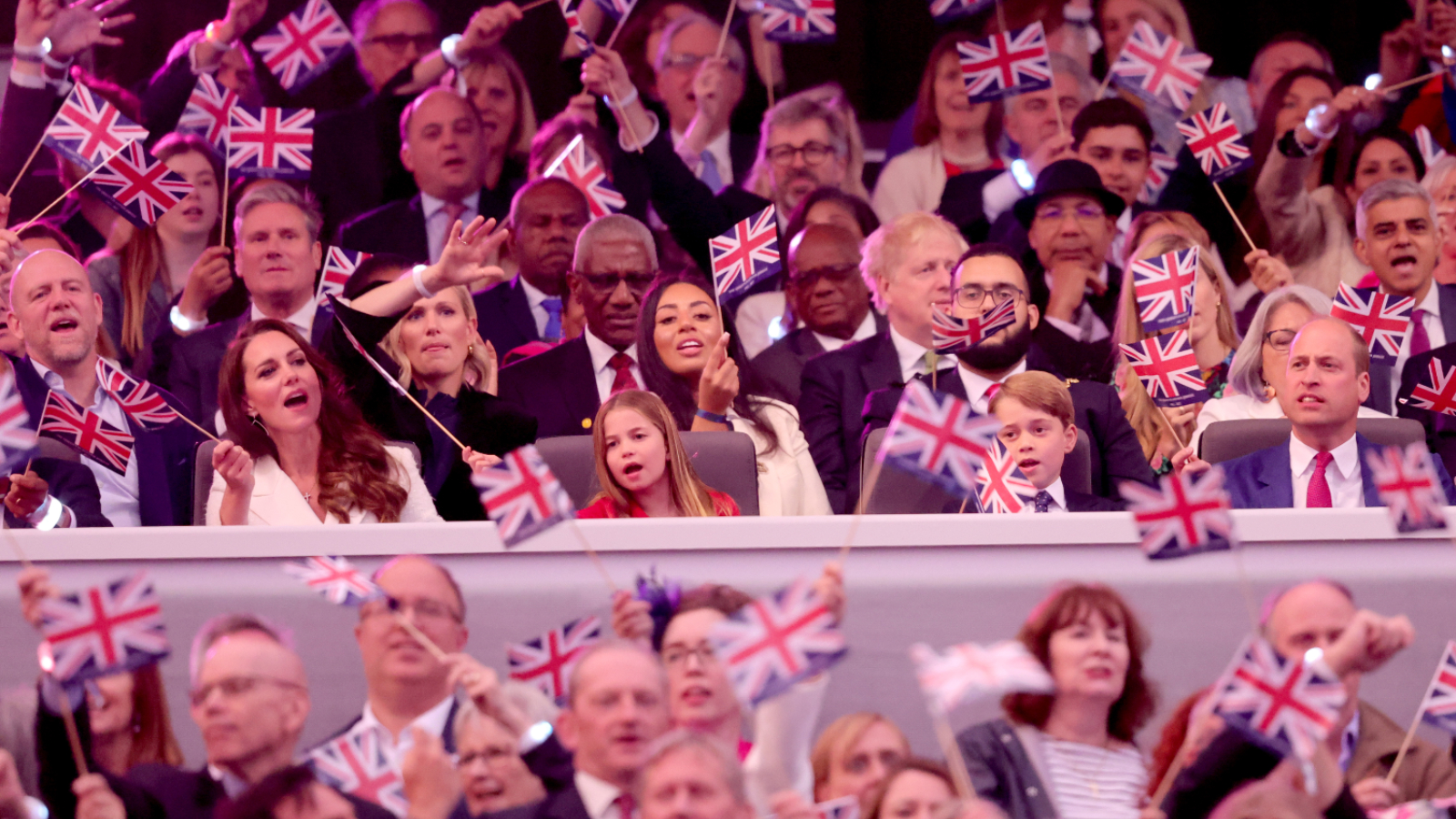 royal eurovision Catherine, Duchess of Cambridge, Princess Charlotte of Cambridge, Prince George of Cambridge, Prince William, Duke of Cambridge wave Union Jack flags as 'Sweet Caroline' plays during the Platinum Party at the Palace in front of Buckingham Palace on June 04, 2022 in London, England.