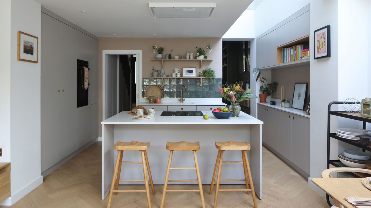 Kitchen with central island. contemporary units and white work surface and neutral colour scheme