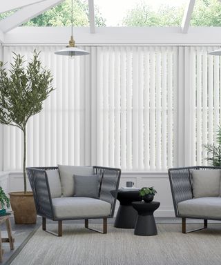 Press loft - White vertical blinds hanging in a cool toned sitting space