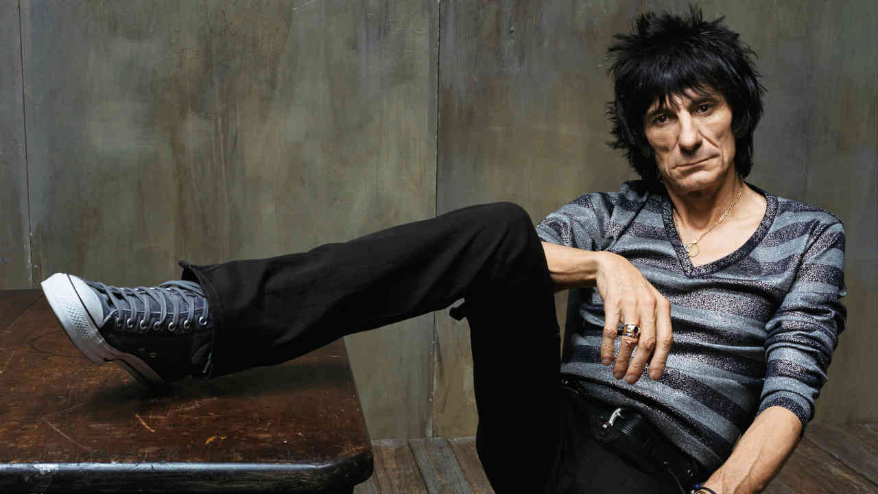 Ronnie Wood of the Rolling Stones with his foot on a table