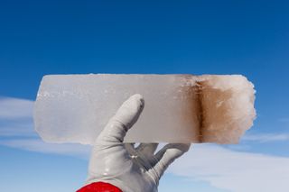 researcher holds up an ice core