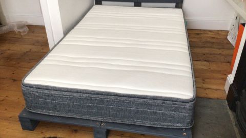 Origin Hybrid mattress on a bed frame in reviewer's bedroom