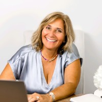 A headshot of a woman with a blonde bob smiling at the camera