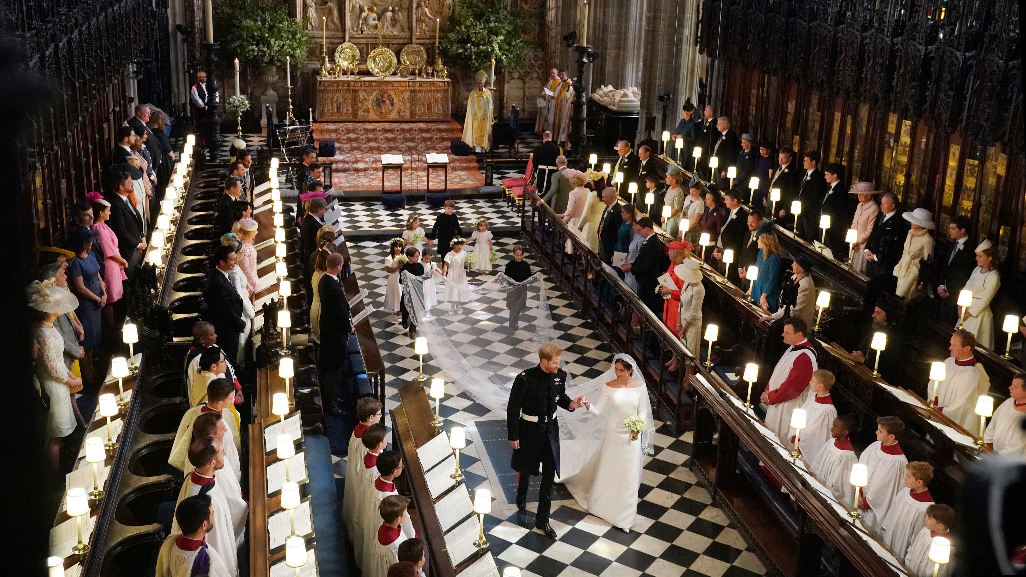 Princ Harry, vévoda ze Sussexu a vévodkyně ze Sussexu jdou uličkou na svatebním obřadu v kapli svatého Jiří na zámku Windsor dne 19. května 2018