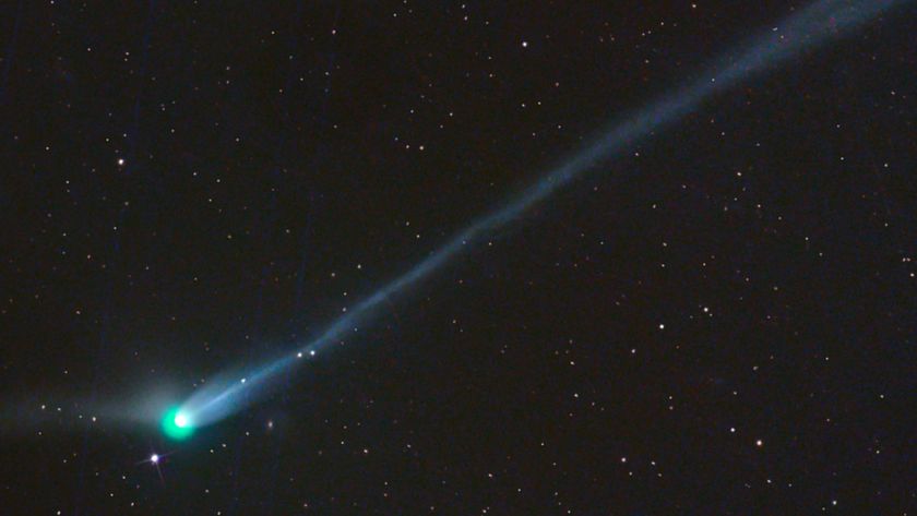 A photo of the green comet with a long tail in the night sky
