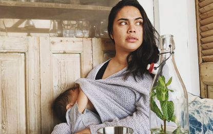 Woman in cafe breastfeeding her baby