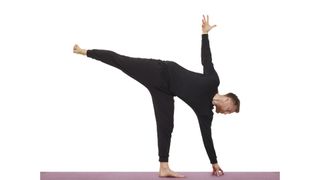 Yoga instructor Nick Higgins performs half moon pose