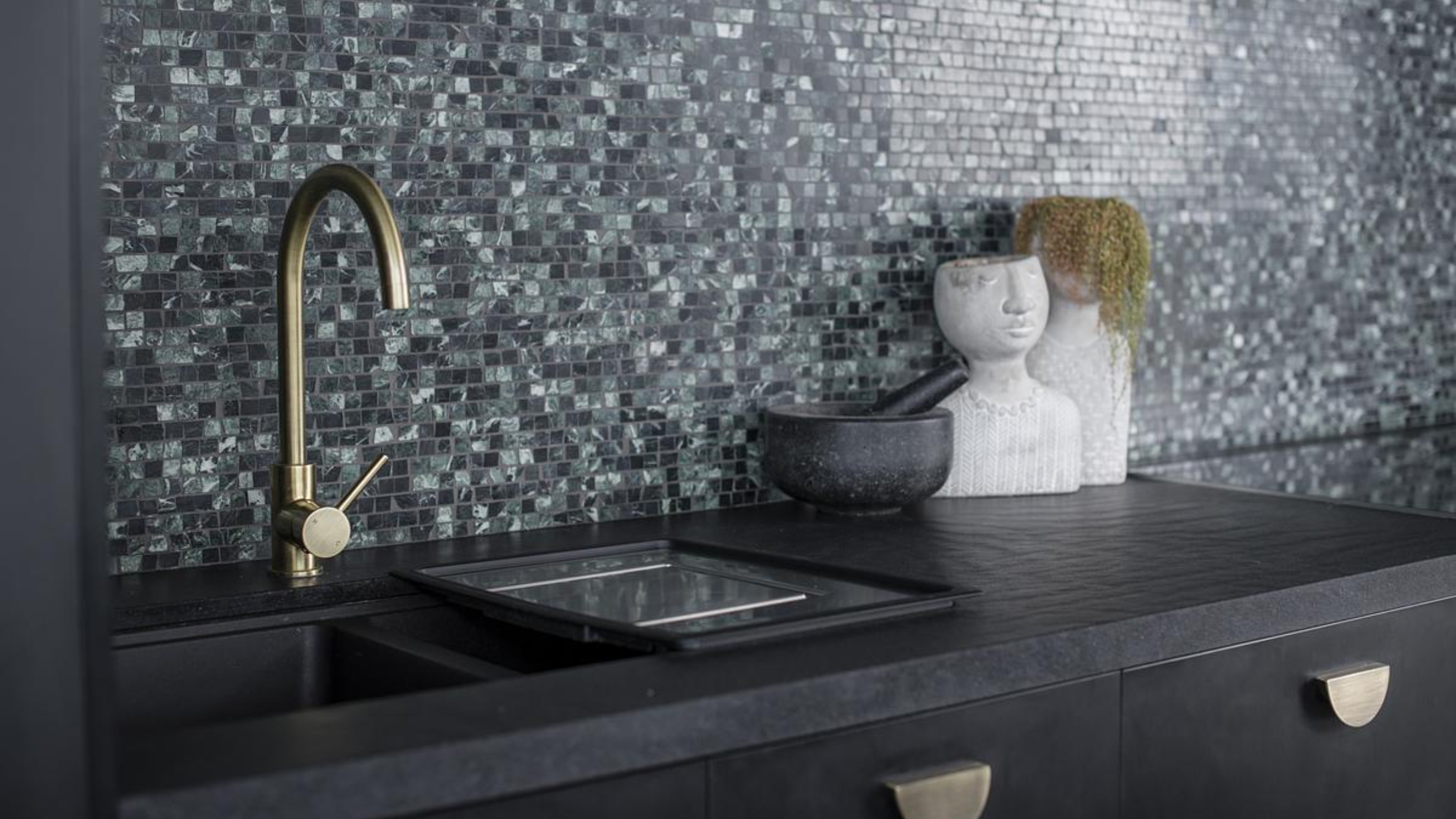 a big double kitchen sink in front of a mosaic green backsplash kitchen