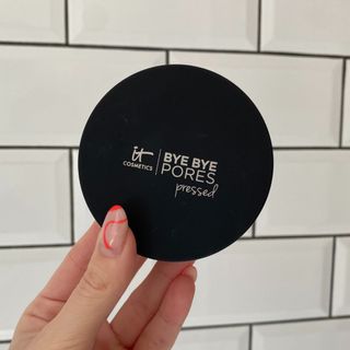 Original image showing hand holding the IT Cosmetics Bye Bye Pores Pressed Powder