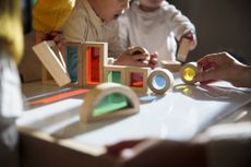 Children playing with colourful wooden building blocks on the table