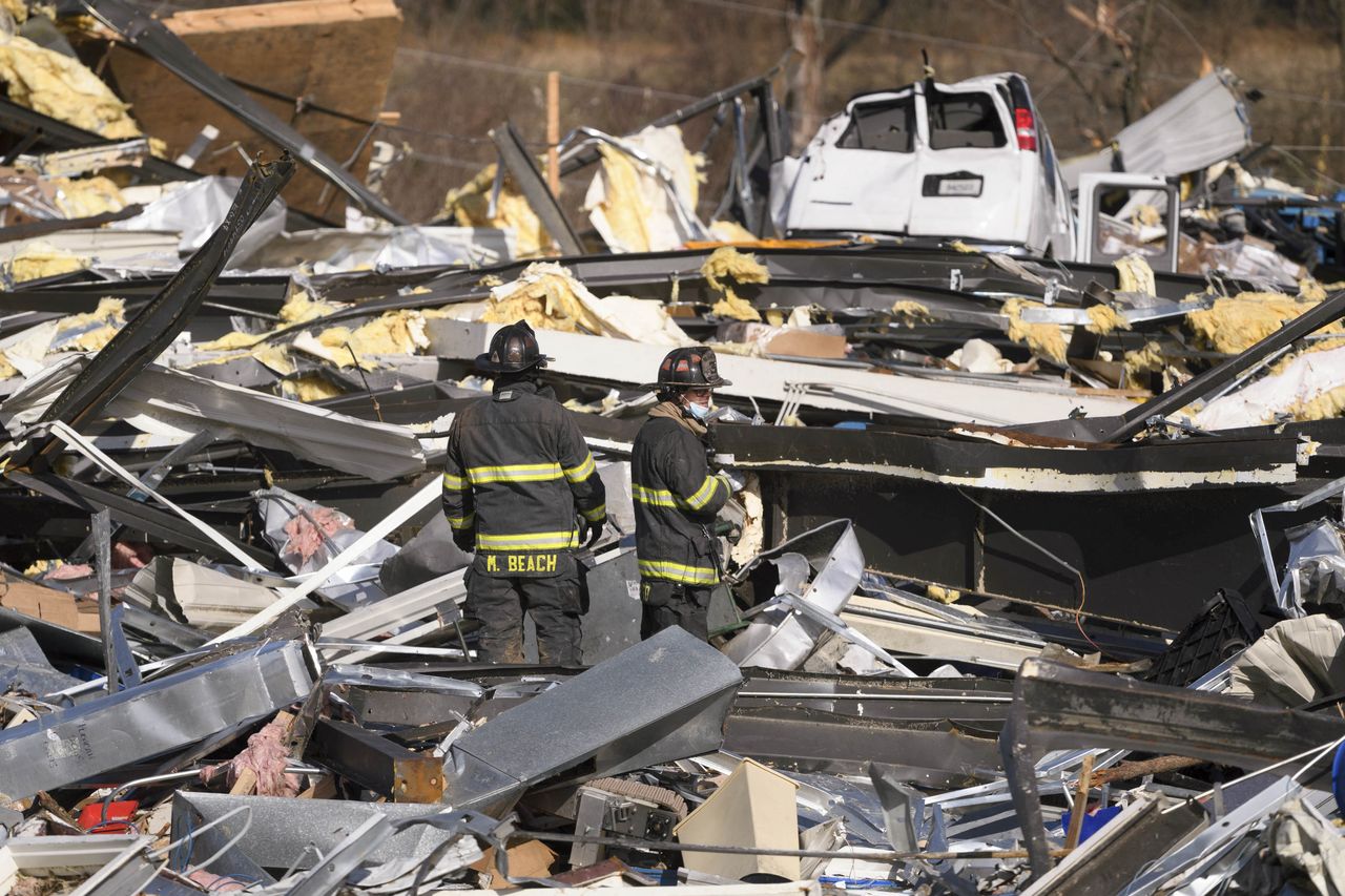 Workers search the site of the Mayfield Consumer Products candle factory