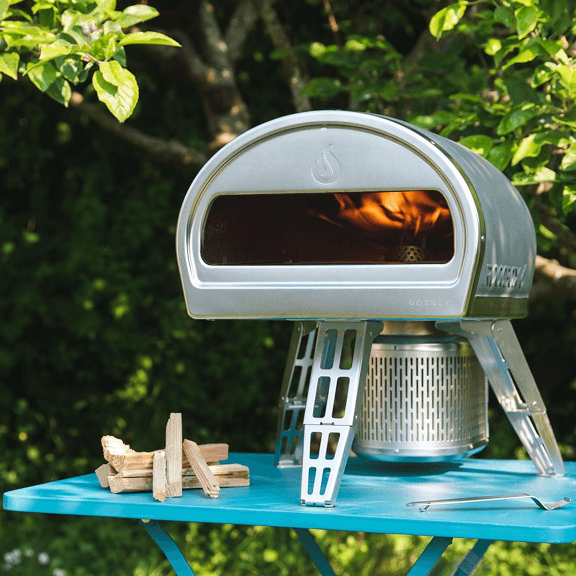 Gozney Roccbox on blue table in back garden
