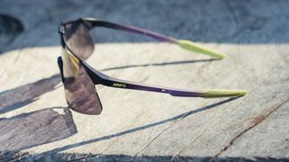 A pair of 100% Hypercraft cycling glasses on a wooden bench