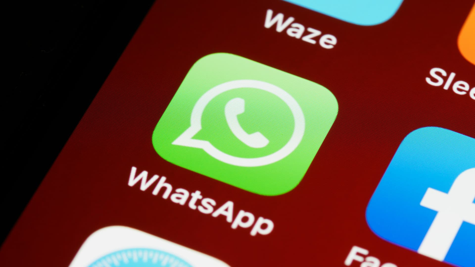 The WhatsApp icon on an iPhone's display.