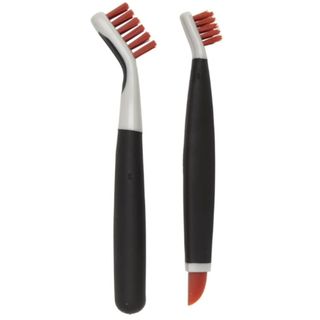 two black and silver brushes for deep cleaning with orange details