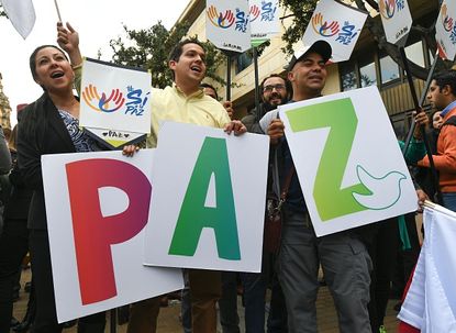People celebrate in Colombia with a sign that spells "peace."