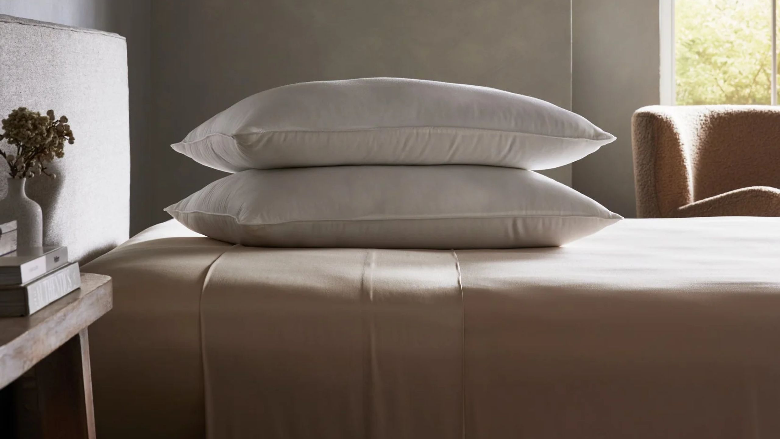 Two Cozy Earth Bamboo Down Alternative Pillows on a bed in a neutral, minimalist bedroom.