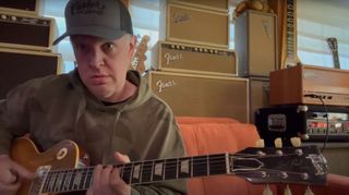 Joe Bonamassa plays a Gibson Les Paul at home in front of a wall of guitar amps