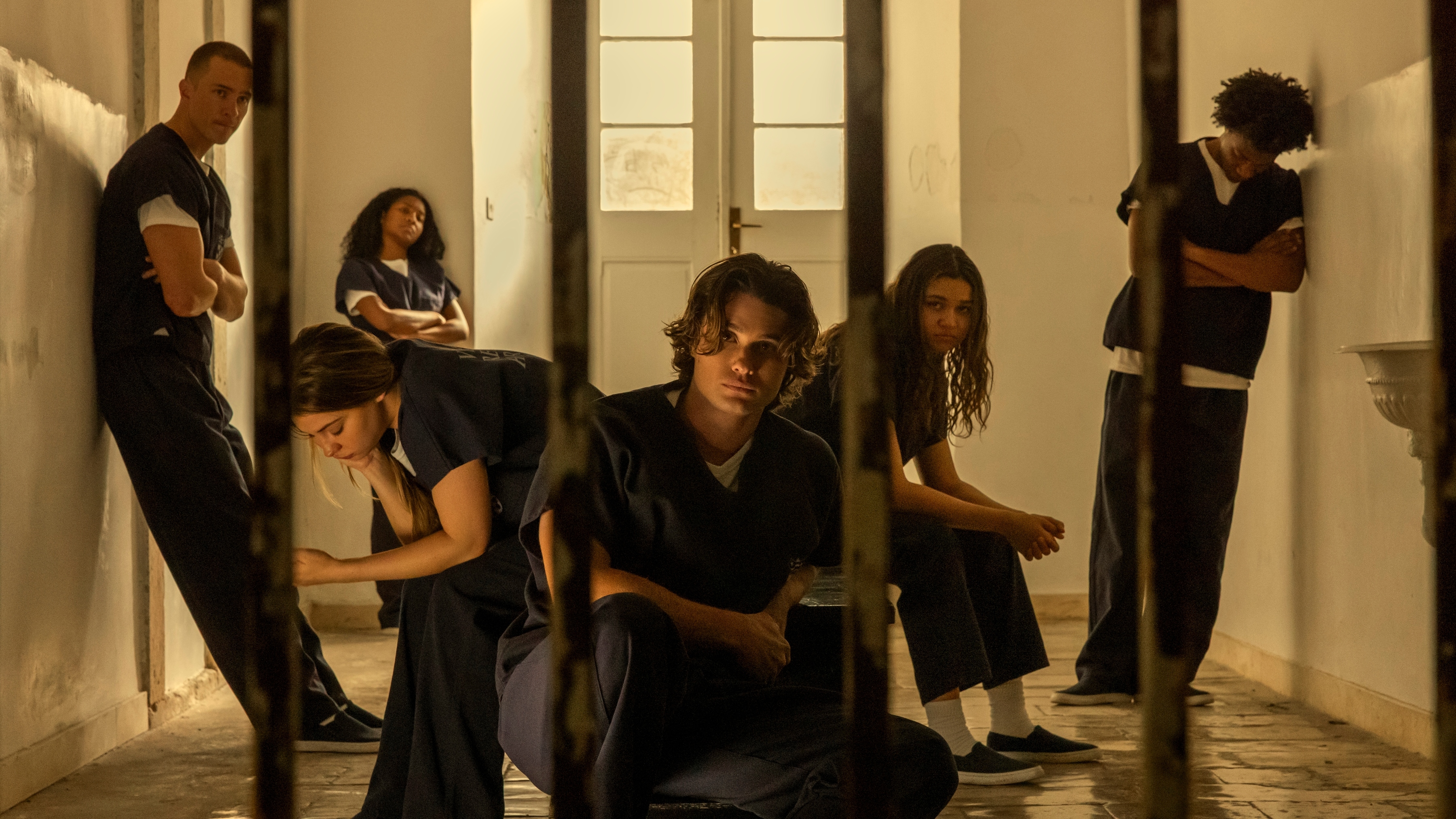 (L to R) Drew Starkey as Rafe, Madelyn Cline as Sarah Cameron, Carlacia Grant as Cleo, Chase Stokes as John B, Madison Bailey as Kiara, and Jonathan Daviss as Pope behind bars in a jail room.