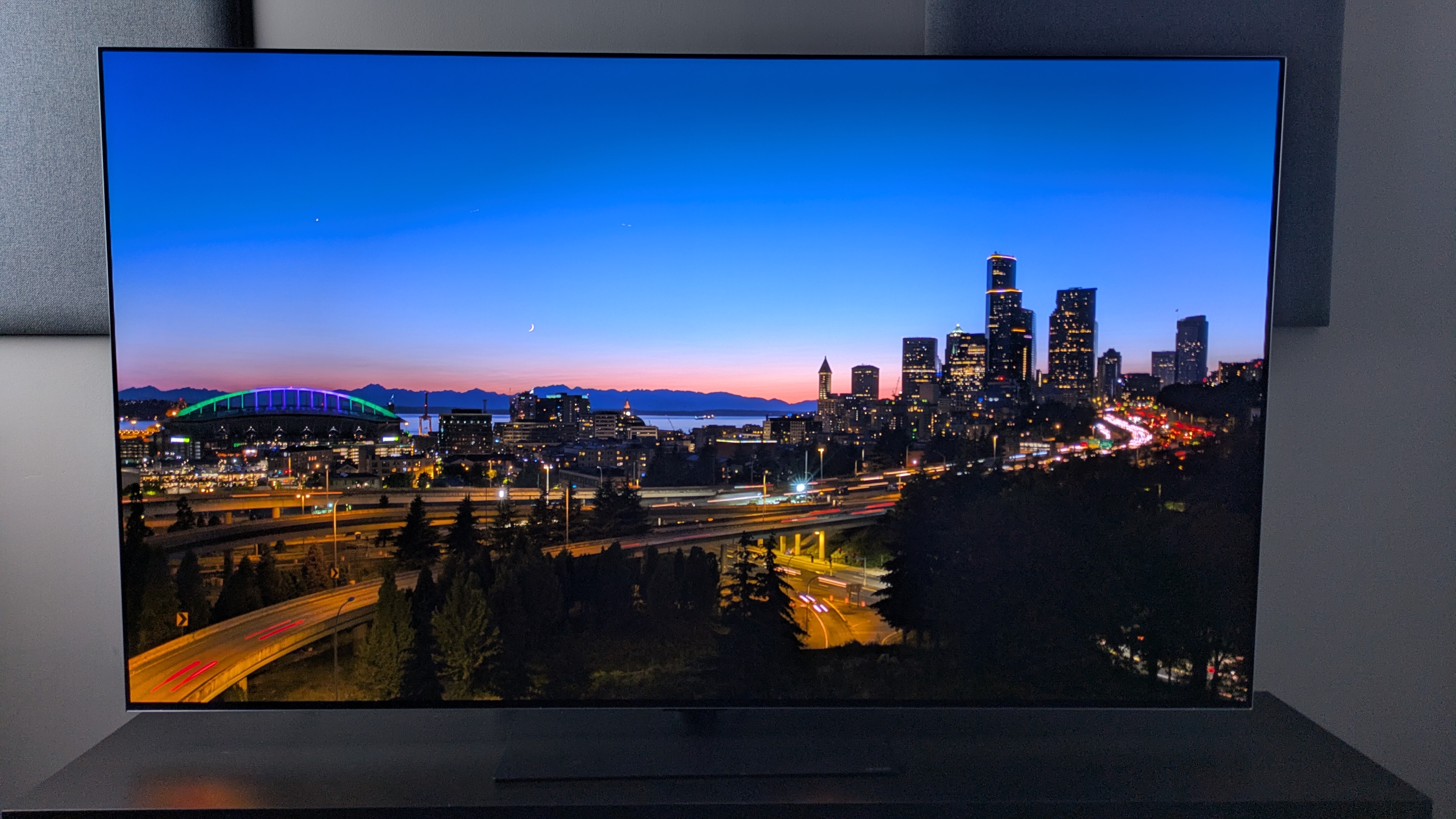 LG G6 OLED TV showing city skyline at dusk on screen