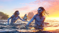 three blue-skinned aliens playing in the water