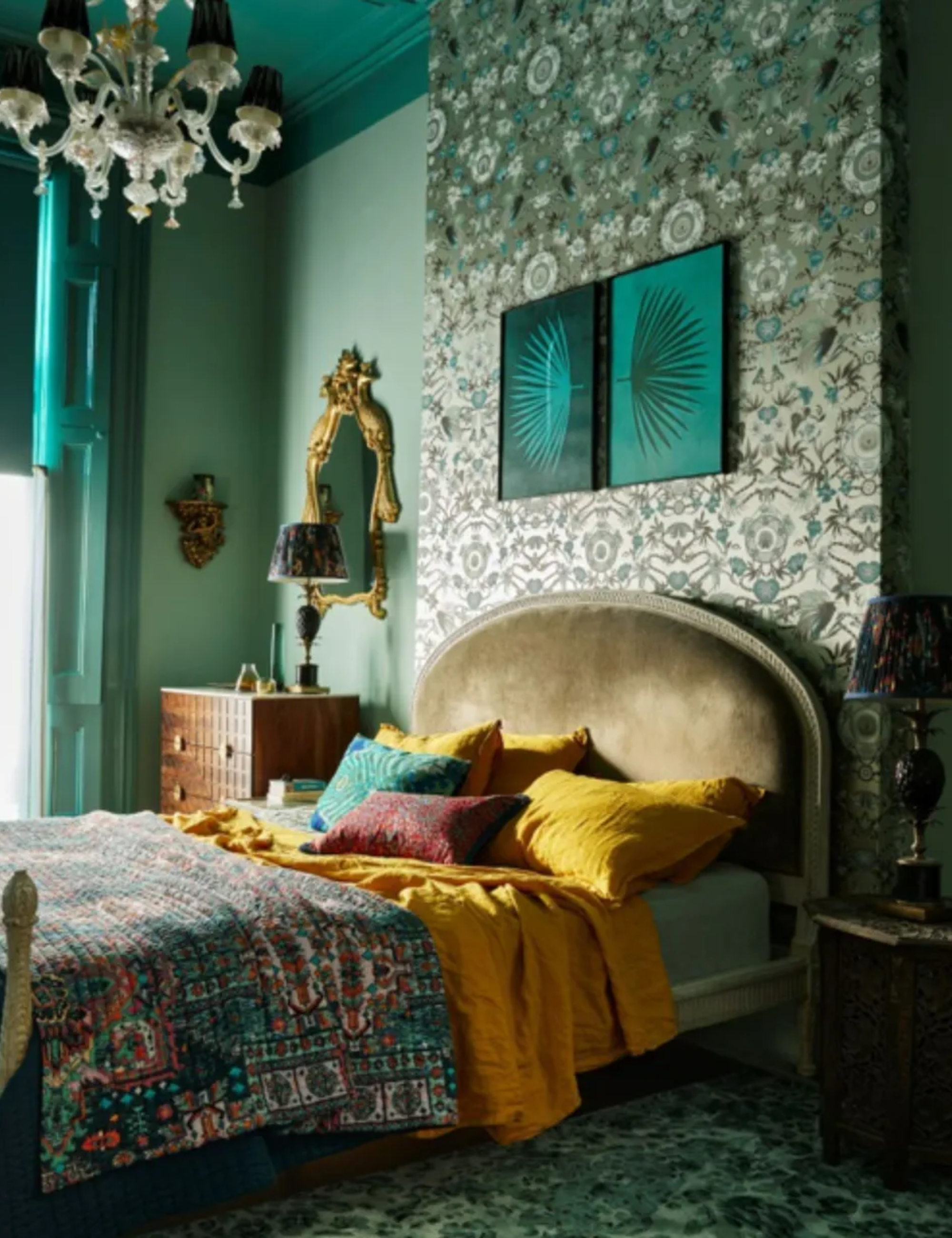 Moody bedroom painted in dark green with hints of yellow and golds