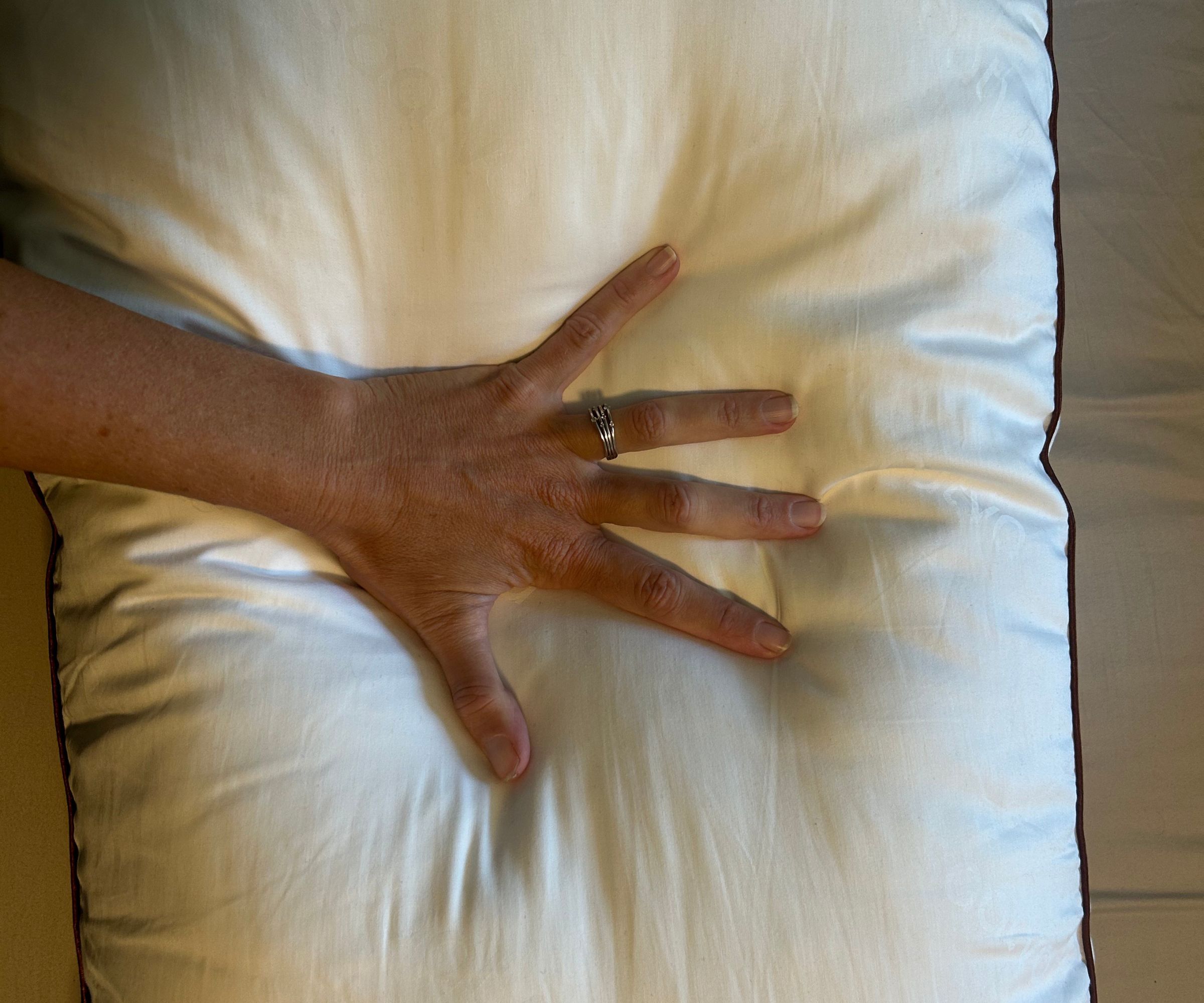 Hand pressing down on a pillow