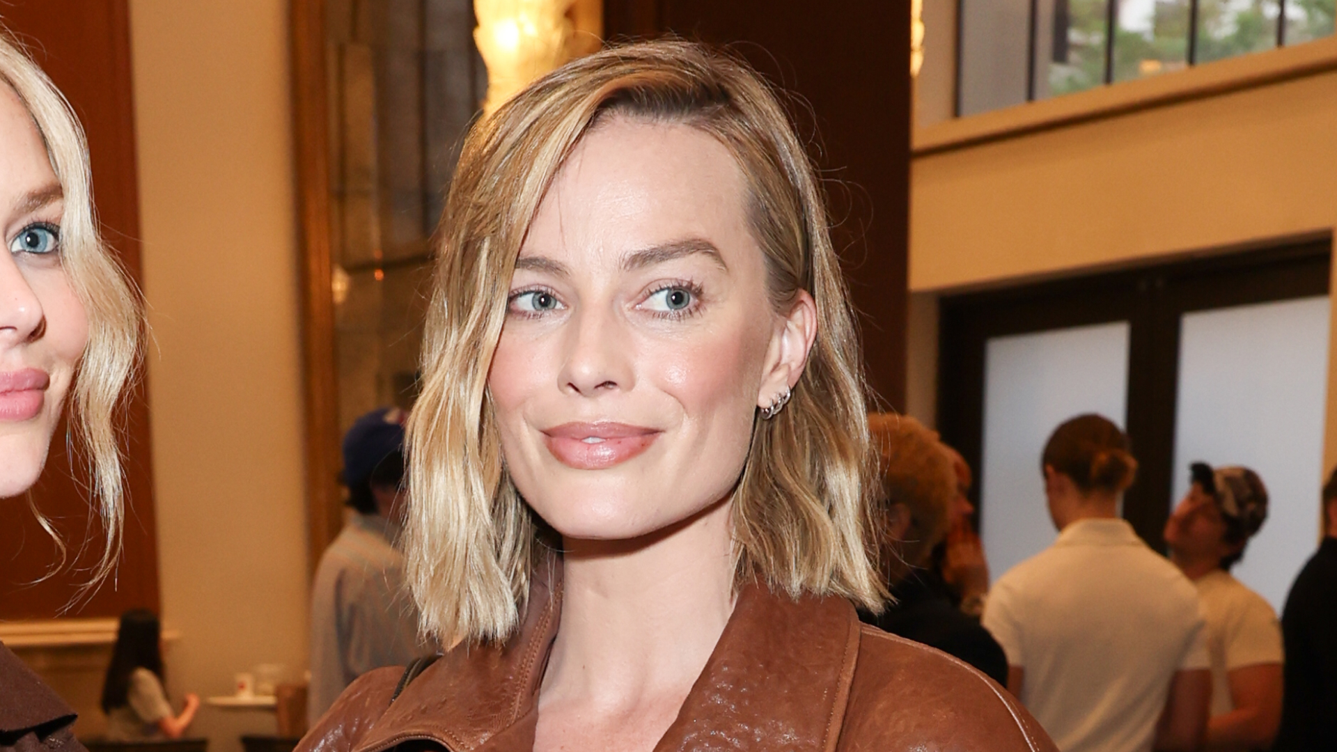 Margot Robbie wears a chestnut leather jacket