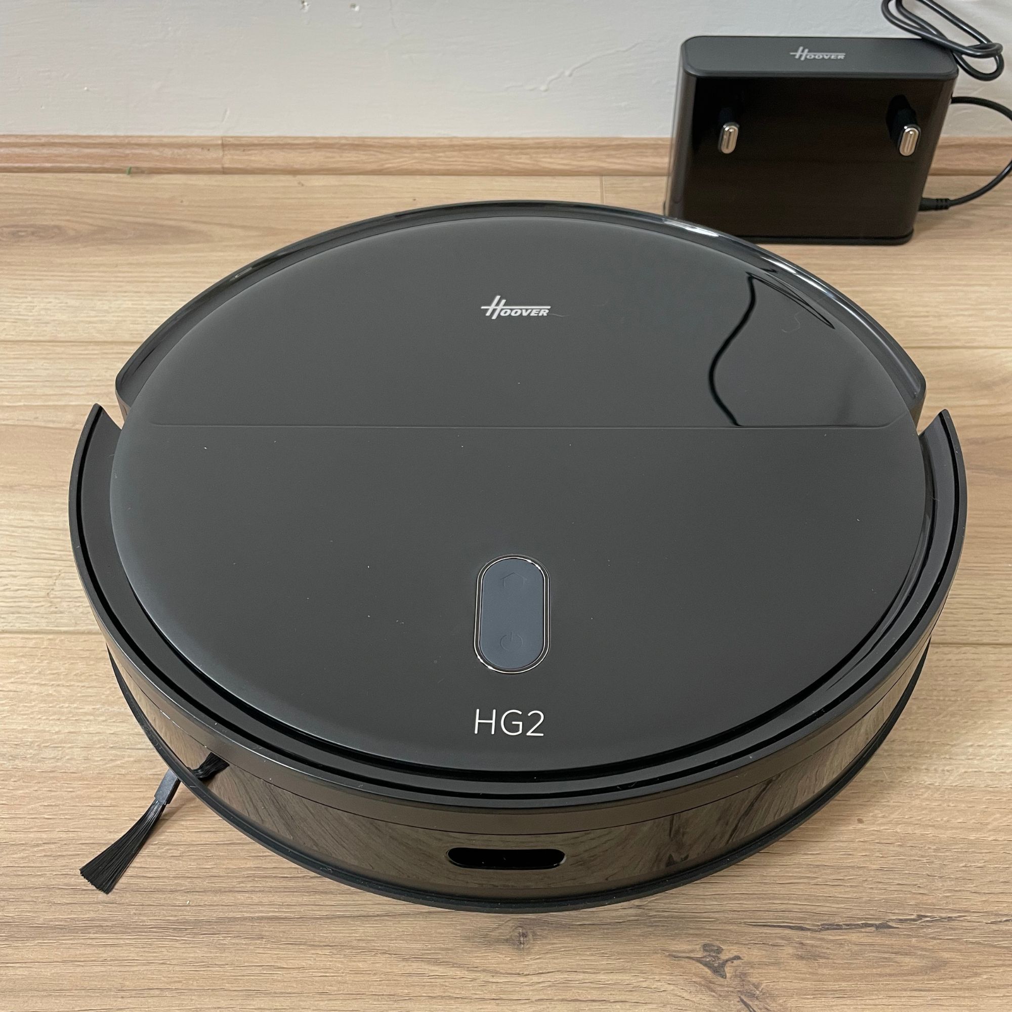Hoover HG2 robot vacuum and mop sitting on wood-effect flooring