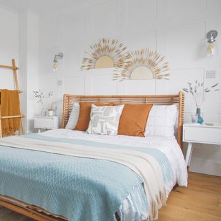 bedroom wall decor ideas, white bedroom with paneling behind bed, pair of fans on wall, wall lights, rattan bed
